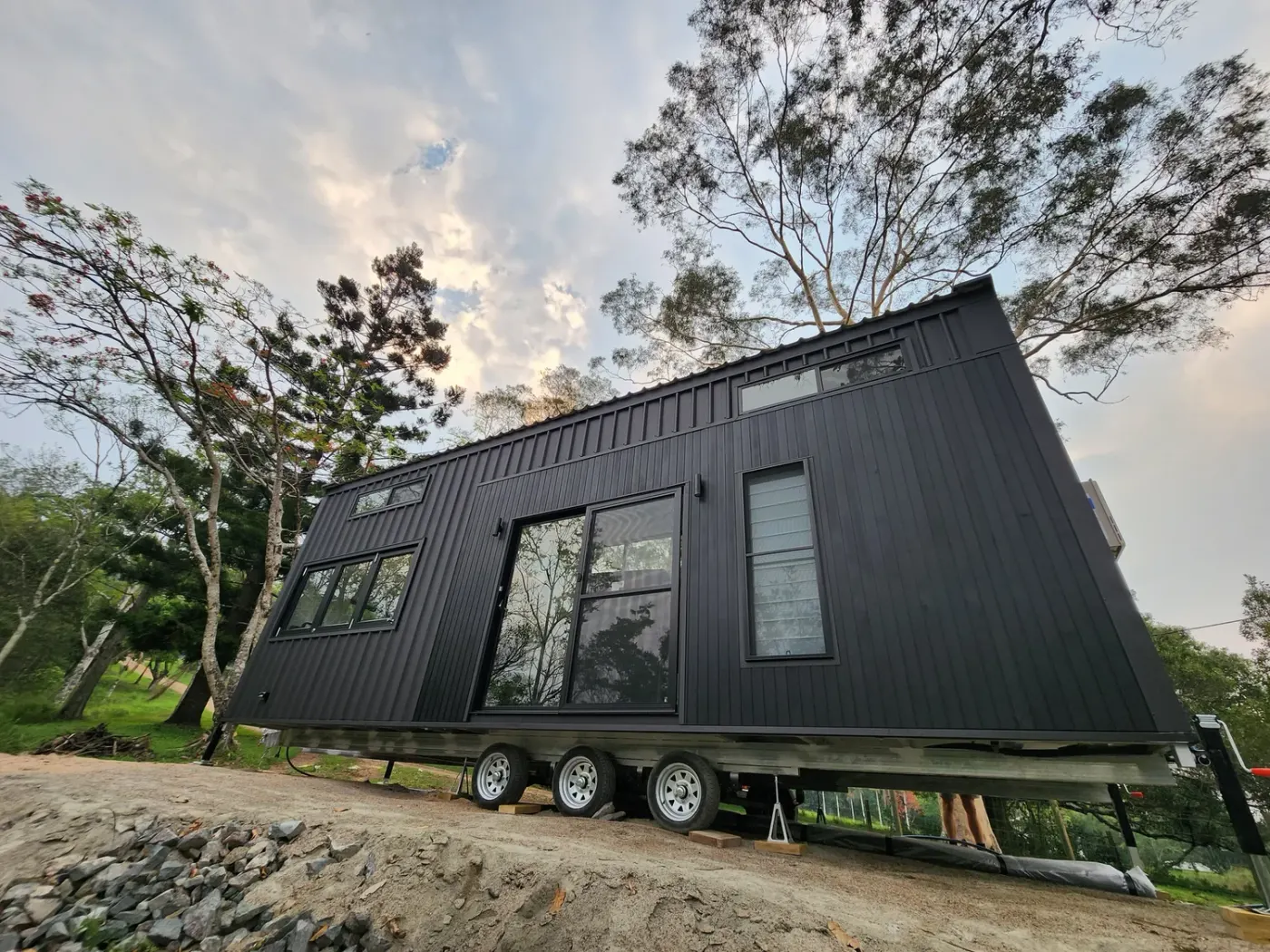 A Sunshine Tiny Houses tiny house on wheels on its trailer